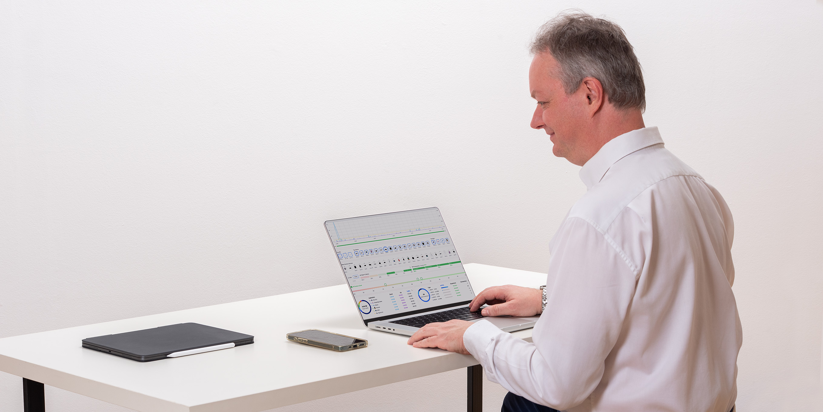 Aufgeräumter Schreibtisch mit Laptop, Tablet und Smartphone